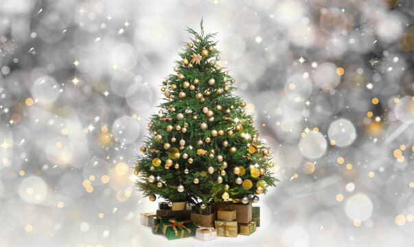 Beautifully decorated Christmas tree and gift boxes on blurred background. Bokeh effect