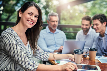 Its the perfect place for a meeting. Cropped portrait of an attractive young businesswoman sitting outdoors at a cafe during a meeting.