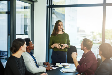 Shes the expert at activating the talent that surrounds her. Shot of a businesswoman delivering a presentation to her coworkers.