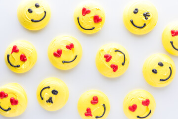 Top down view of several smiley face emoji merengue cookies.