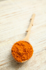 Spoon with saffron powder on white wooden table