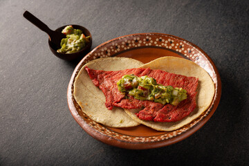 Tacos de Cecina Enchilada con Guacamole. Salted, sun-dried pork or beef meat, seasoned with various spices and chili peppers, usually eaten in tacos