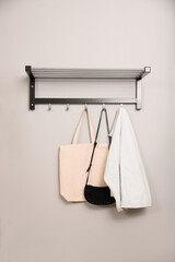 Fototapeta na wymiar Bags and clothes on coat rack in hallway. Interior element