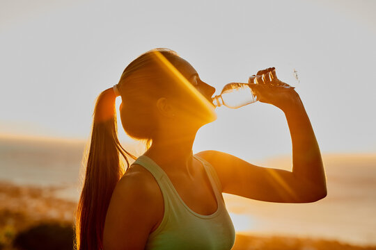 Staying hydrated. Cropped shot of an attractive young woman getting a drink during her workout.