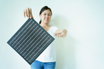 Young woman showing the used dirty air purifier filter to camera. 