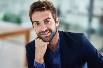 Naklejka premium Aiming for success. Portrait of a young businessman sitting in an office.