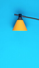 Stylish yellow lamp on a blue background. Minimal business concept.