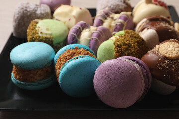 Delicious colorful macarons on plate, closeup view