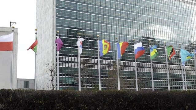 South Korea, Qatar and Russian flag flying slow motion in the wind. United Nations headquarter Building. International community and security