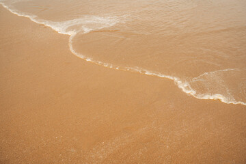 Fototapeta na wymiar Closeup soft wave of the sea on the sandy beach.