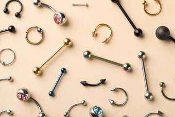 Stylish jewelry for piercing on beige background, flat lay - obrazy, fototapety, plakaty