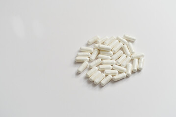 Lot's of white pills on white background for healthcare