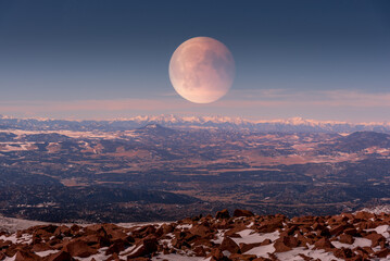 Full moon rising on the Rocky Mountains at Pikes Peak