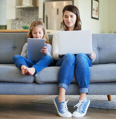 This is our mother and daughter time. Shot of a young mother and daughter using a laptop and...