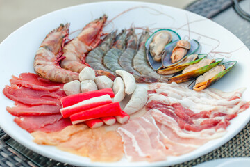 Assortment of fresh seafood, meat for cooking in grill or hot pot. Traditional asian food - raw river prawn or shrimps prepared for Japanese shabu shabu or sukiyaki. Healthy steamed food