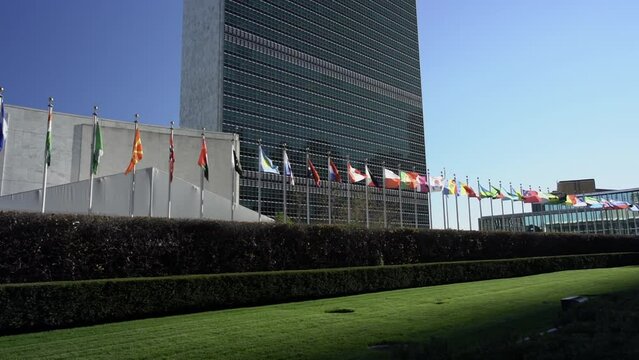 Flags in front of United Nations in NYC. International community. Flags flying in the wind in slow motion