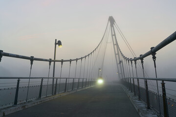 Hängebrücke am Herrenkrug am Elberadweg bei Magdeburg mit Licht eines Fahrradfahrers im Nebel 