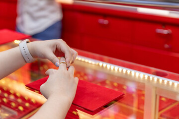 A customer comes to buy a ring and is trying to wear a ring on his finger.
