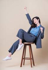 Full length image of young Asian business woman on background