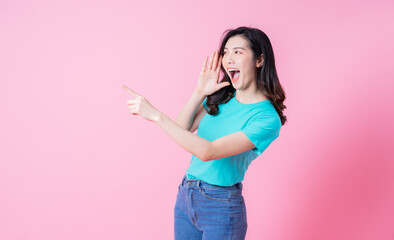 Portrait of young Asian woman on pink background