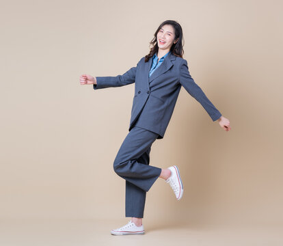 Full length image of young Asian business woman on background
