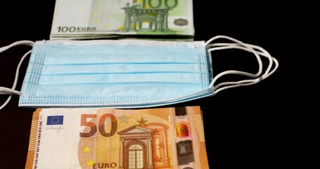 Euro banknotes piled up next to Face masks. Cost of masks and protection against Covid-19 - Powered by Adobe