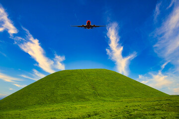 Fototapeta na wymiar 阿蘇地方の米塚上空を飛ぶ飛行機