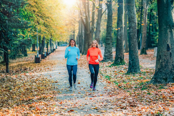 Fototapeta premium Friends Jogging Outdoors in a Public Park. Autumn, Fall.