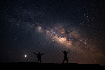 Naklejka na ściany i meble Two men happily stood beside the Milky Way Galaxy and pointed to a bright star.