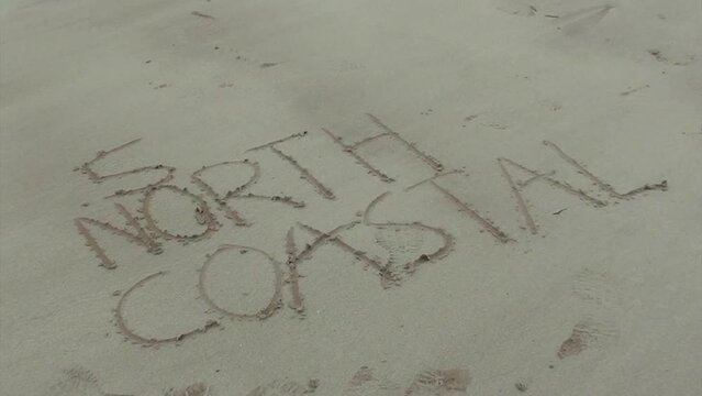 North Coastal 500 written in sand on a Scotch beach