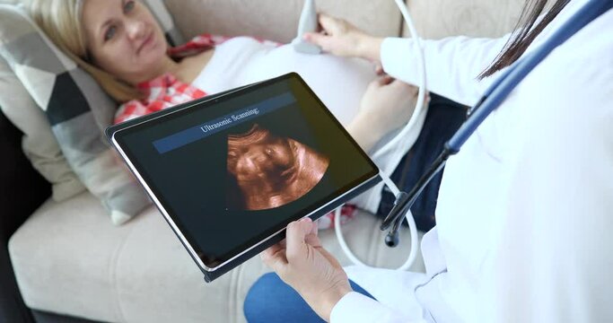 Gynecologist conducts ultrasound of child to pregnant woman at home
