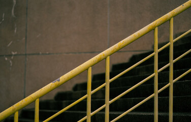 Yellow guardrails of an outdoor staircase.