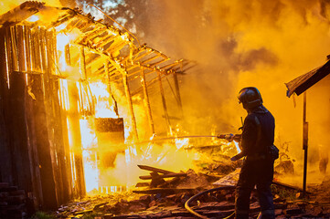 Firefighters extinguish a fire in a farm building