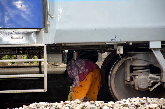 People Risking Their Lives By Ducking Under The Train To Reach Other Side