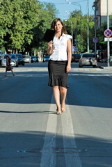 Pretty businesswoman walking on road