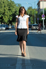 Pretty businesswoman walking on road