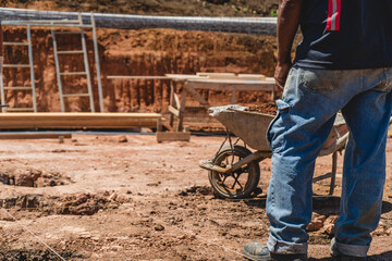 Unknown person standing outdoors in the middle of the first surface preparations to start building a house. 