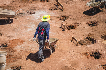 Unknown man with a wheelbarrow working in a construction site
