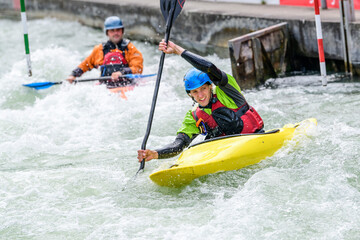 Zwei Kajakfahrer kämpfen sich souverän durch das Wildwasser 