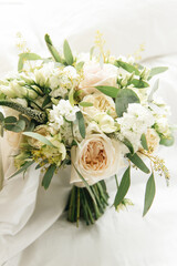 A luxurious wedding bouquet with peony-shaped roses and green branches