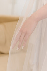 Morning of the bride, details of the wedding day, the bride's hand under the veil