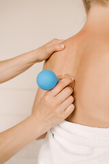 Massage and body care. A young woman receives a relaxing and toning neck and back massage with rubber cans at the spa.