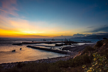 Obraz premium Seaport industry - Transportation and logistic . Industrial cranes and ships in the sunset.