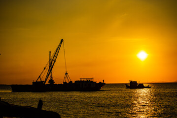 Seaport industry - Transportation and logistic . Industrial cranes and ships in the sunset.