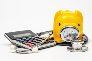 Medical expenses concept with piggy bank, calculator and stethoscope
