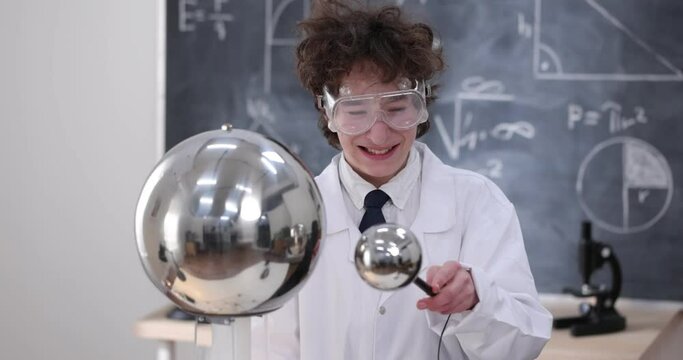 A boy conducts physical experiments with electricity, a plasma ball, and a Van de Graaff Generator.