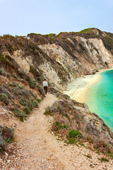 The Beach of Sansone on Elba island in Italy with unrecognizable trekker. Tuscan Archipelago national park. Mediterranean sea coast. Vacation and tourism concept.