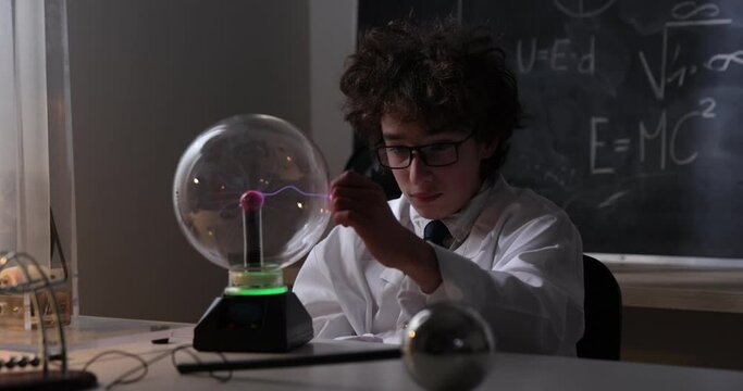 Schoolboy experimenting in physics class. Young student doing physics experiment in the classroom