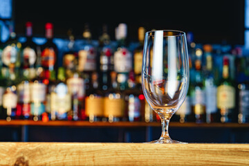 Empty beer glass on a wooden bar counter
