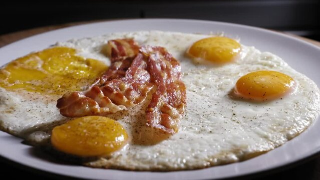 Close Up Of Fried Eggs And Bacon Strips For Breakfast.
